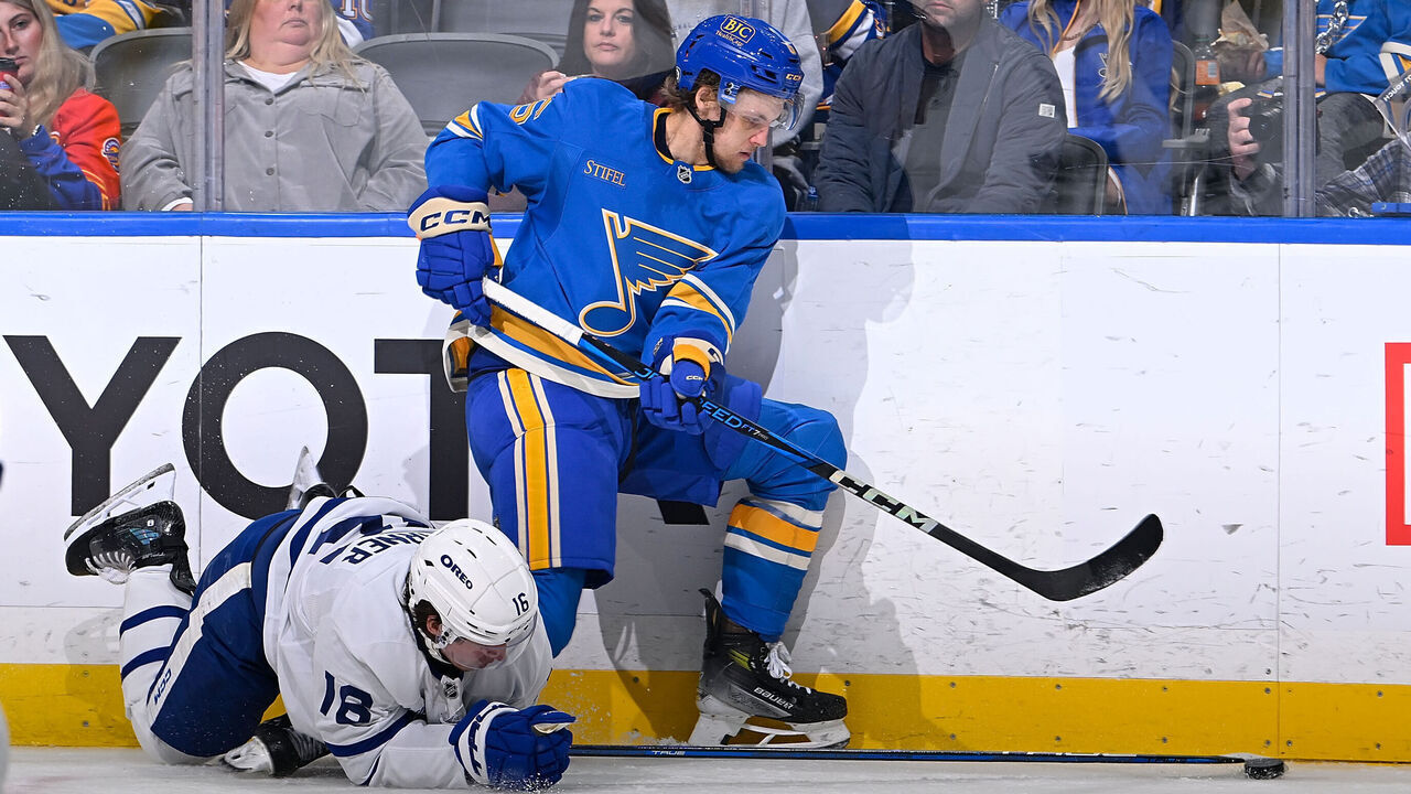 ST. LOUIS, MO - NOVEMBER 2: Steven Lorentz #18 of the Toronto Maple Leafs reaches for the puck against Philip Broberg #6 of the St. Louis Blues on November 2, 2024 at the Enterprise Center in St. Louis, Missouri.