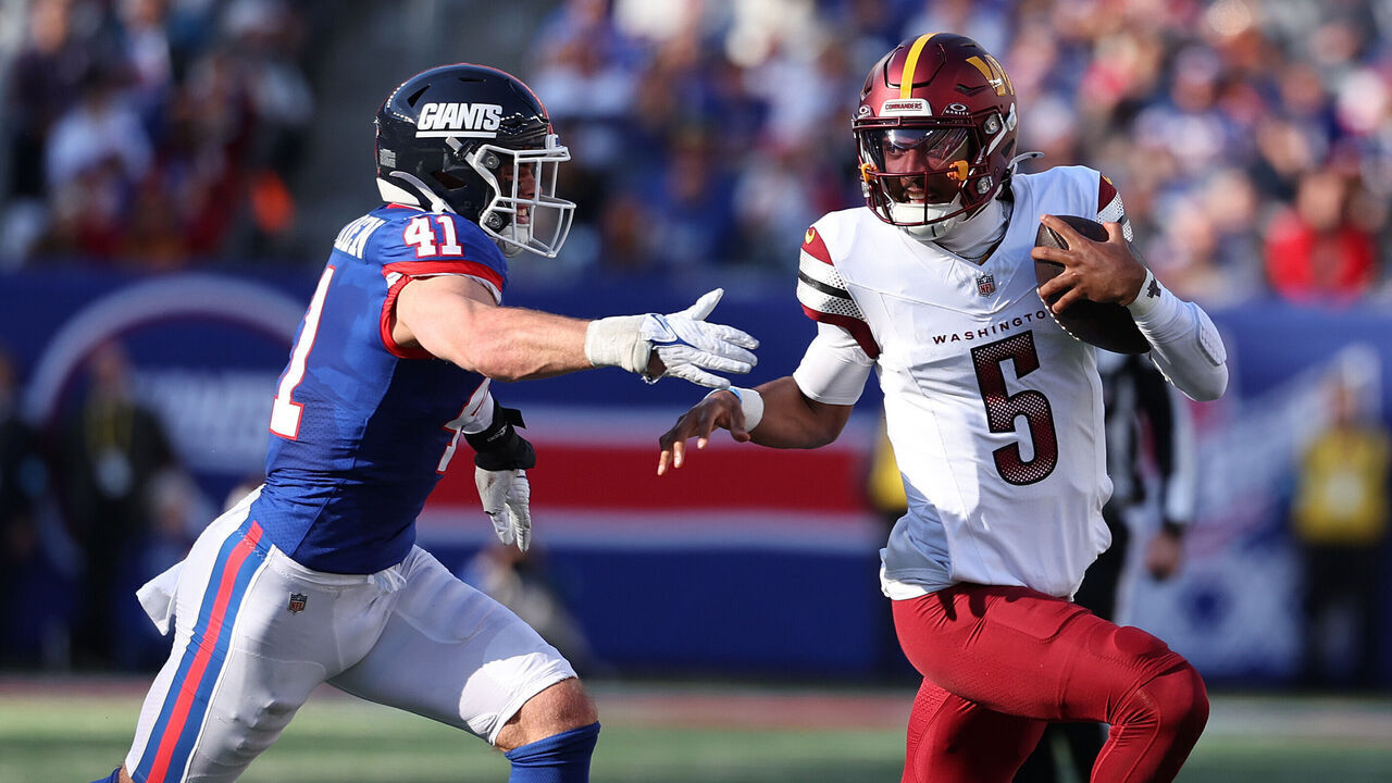 EAST RUTHERFORD, NEW JERSEY - NOVEMBER 03: Jayden Daniels #5 of the Washington Commanders is chased by Micah McFadden #41 of the New York Giants during the first half at MetLife Stadium on November 03, 2024 in East Rutherford, New Jersey.