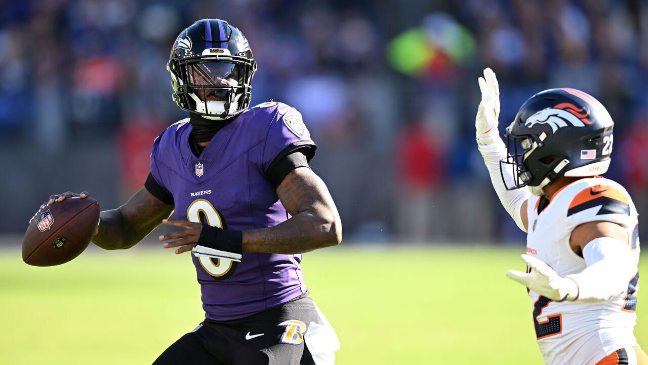 BALTIMORE, MARYLAND - NOVEMBER 03: Brandon Jones #22 of the Denver Broncos pressures Lamar Jackson #8 of the Baltimore Ravens in the second quarter of a game at M&T Bank Stadium on November 03, 2024 in Baltimore, Maryland.