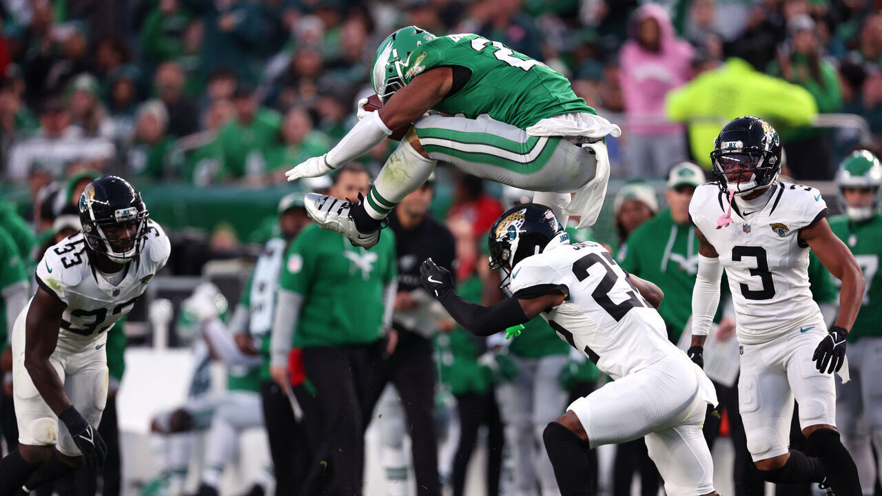 PHILADELPHIA, PENNSYLVANIA - NOVEMBER 03: Saquon Barkley #26 of the Philadelphia Eagles hurdles Jarrian Jones #22 of the Jacksonville Jaguars in the second quarter of a game at Lincoln Financial Field on November 03, 2024 in Philadelphia, Pennsylvania.