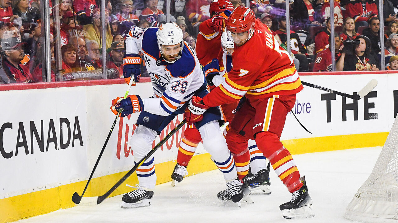 CALGARY, CANADA - NOVEMBER 3: Kevin Bahl #7 of the Calgary Flames battles Leon Draisaitl #29 of the Edmonton Oilers for the puck during the first period at Scotiabank Saddledome on November 3, 2024 in Calgary, Alberta, Canada.