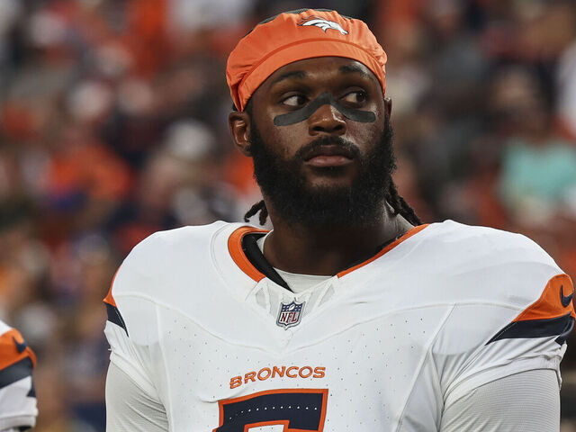 DENVER, CO - AUGUST 18: Baron Browning #5 of the Denver Broncos looks on from the sideline during the national anthem prior to an NFL football game against the Green Bay Packers at Empower Field at Mile High on August 18, 2024 in Denver, CO.