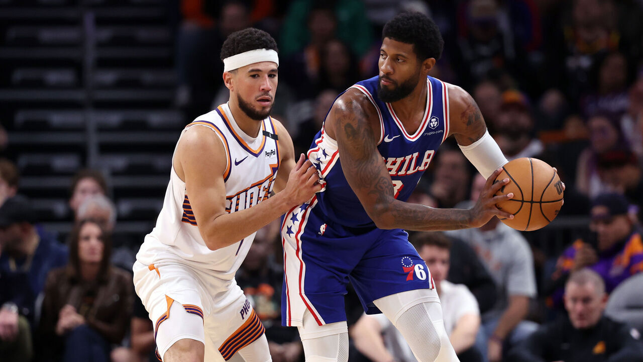 PHOENIX, ARIZONA - NOVEMBER 04: Paul George #8 of the Philadelphia 76ers posts up on Devin Booker #1 of the Phoenix Suns during the second half at Footprint Center on November 04, 2024 in Phoenix, Arizona.