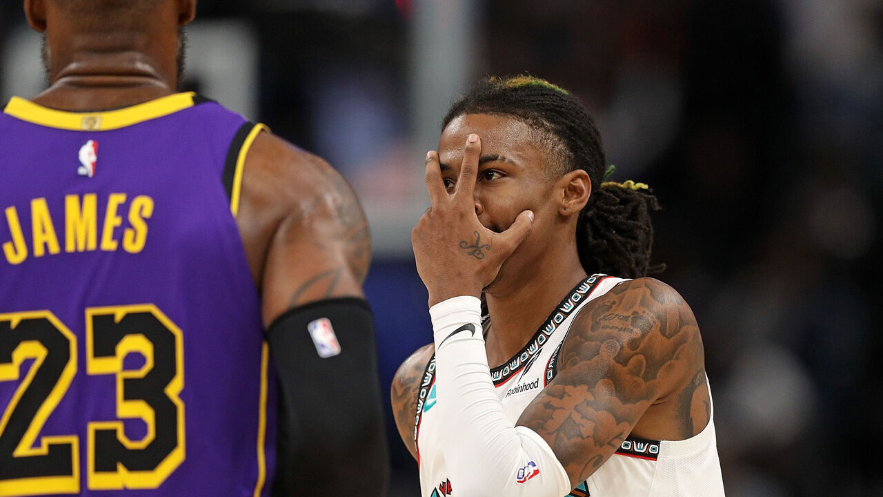 MEMPHIS, TENNESSEE - NOVEMBER 06: Ja Morant #12 of the Memphis Grizzlies reacts against LeBron James #23 of the Los Angeles Lakers during the first half at FedExForum on November 06, 2024 in Memphis, Tennessee.