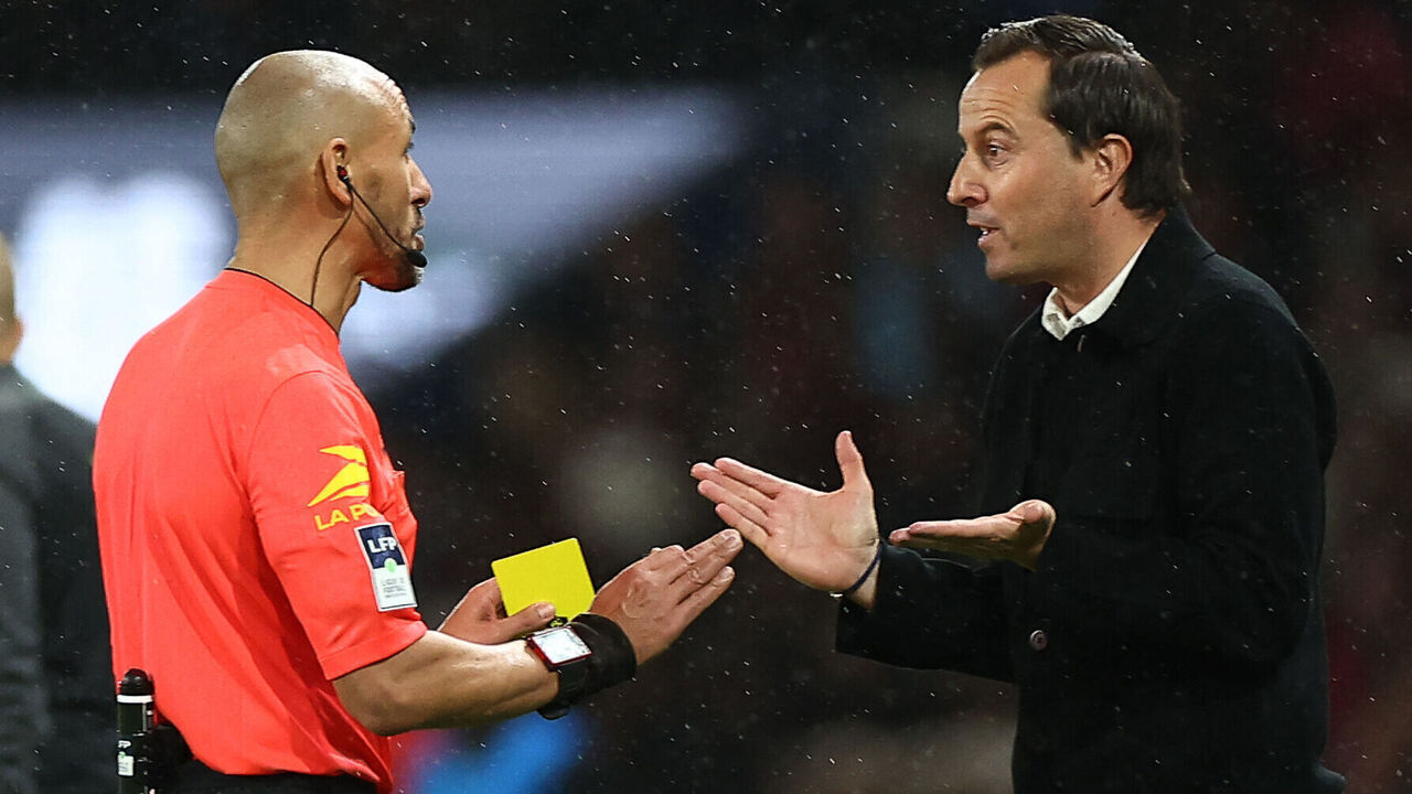 Rennes' French head coach Julien Stephan (R) talks to the referee Hakim Ben El Hadj before beiong showed a yellow card during the French L1 football match between Paris Saint-Germain (PSG) and Stade Rennais FC at The Parc des Princes Stadium in Paris on September 27, 2024.