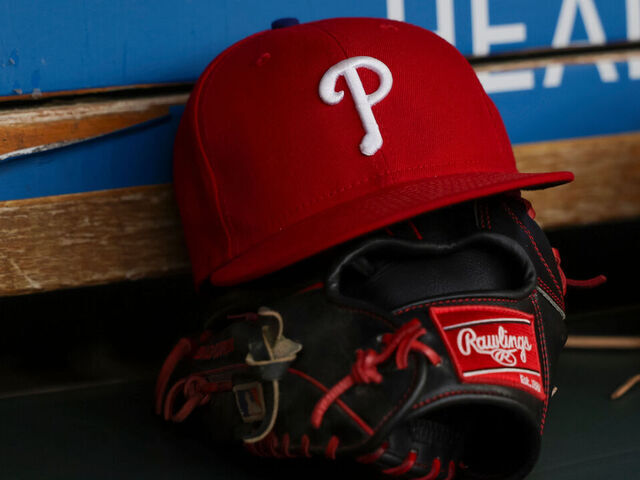 DETROIT, MICHIGAN - JUNE 26: A detail view of the Philadelphia Phillies logo on a hat and a Rawlings glove in the dugout prior to the start of the game against the Detroit Tigers at Comerica Park on June 26, 2024 in Detroit, Michigan.
