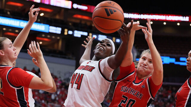 LOUISVILLE, KENTUCKY - NOVEMBER 08: Olivia Cochran #44 of the Louisville Cardinals and Vanessa Shafford #20 of the Southern Indiana Screaming Eagles reach for a loose ball at KFC YUM! Center on November 08, 2024 in Louisville, Kentucky.
