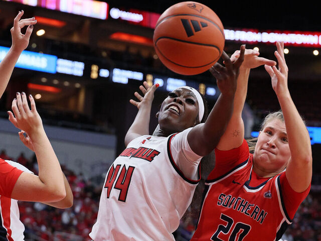 LOUISVILLE, KENTUCKY - NOVEMBER 08: Olivia Cochran #44 of the Louisville Cardinals and Vanessa Shafford #20 of the Southern Indiana Screaming Eagles reach for a loose ball at KFC YUM! Center on November 08, 2024 in Louisville, Kentucky.