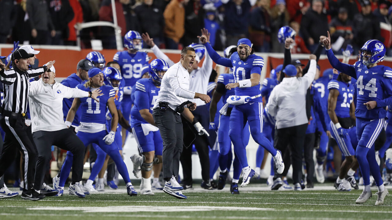 SALT LAKE CITY, UT - NOVEMBER 9: Kelly Poppinga special teams coach of the Brigham Young Cougars celebrates with members of the team after beating the Utah Utes at Rice-Eccles Stadium on November 9, 2024 in Salt Lake City, Utah.