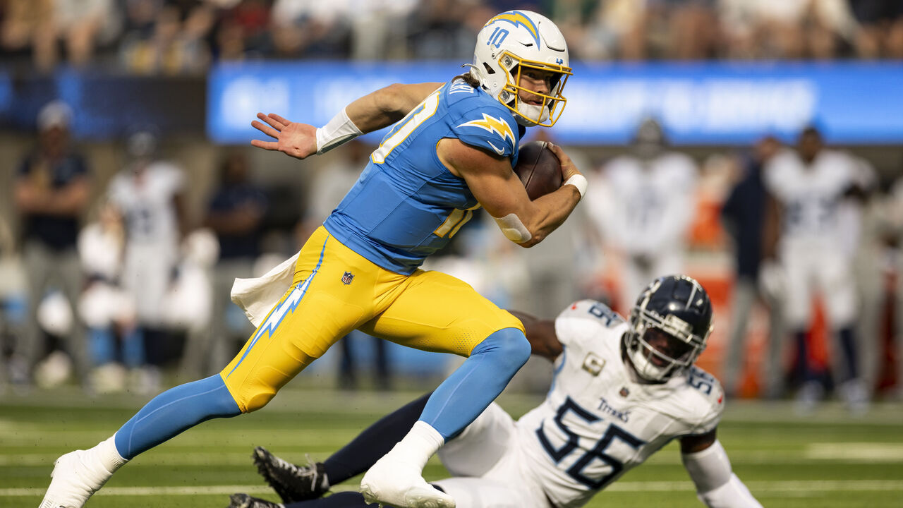INGLEWOOD, CALIFORNIA - NOVEMBER 10: Justin Herbert #10 of the Los Angeles Chargers runs with the ball against Kenneth Murray Jr. #56 of the Tennessee Titans during an NFL Football game at SoFi Stadium on November 10, 2024 in Inglewood, California.