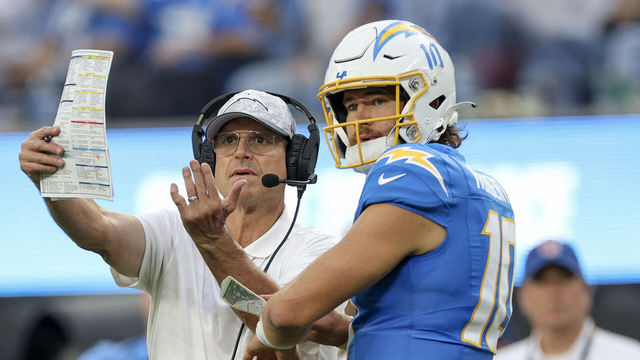INGLEWOOD, CALIFORNIA - NOVEMBER 10: Head coach Jim Harbaugh of the Los Angeles Chargers talks to Justin Herbert #10 in the fourth quarter of a game against the Tennessee Titans at SoFi Stadium on November 10, 2024 in Inglewood, California.
