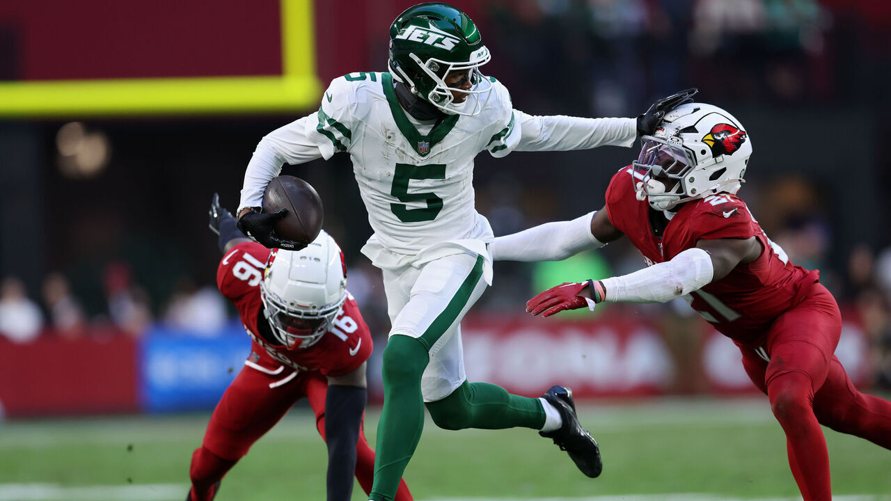 GLENDALE, ARIZONA - NOVEMBER 10: Garrett Wilson #5 of the New York Jets runs with the ball while being chased by Garrett Williams #21 of the Arizona Cardinals in the third quarter at State Farm Stadium on November 10, 2024 in Glendale, Arizona.
