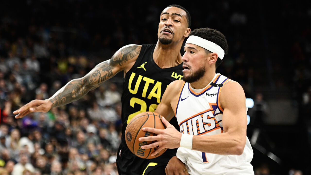 SALT LAKE CITY, UTAH - NOVEMBER 12: Devin Booker #1 of the Phoenix Suns drives into John Collins #20 of the Utah Jazz during the second half of a Emirates NBA Cup game at Delta Center on November 12, 2024 in Salt Lake City, Utah.