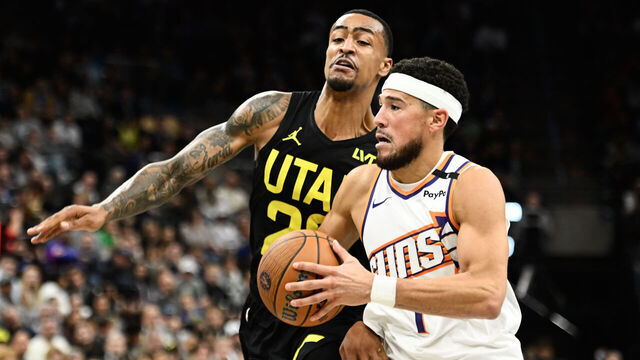 SALT LAKE CITY, UTAH - NOVEMBER 12: Devin Booker #1 of the Phoenix Suns drives into John Collins #20 of the Utah Jazz during the second half of a Emirates NBA Cup game at Delta Center on November 12, 2024 in Salt Lake City, Utah.