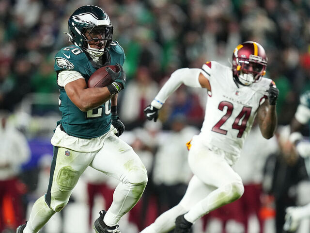 PHILADELPHIA, PENNSYLVANIA - NOVEMBER 14: Saquon Barkley #26 of the Philadelphia Eagles runs by Michael Davis #24 of the Washington Commanders on his way to a touchdown during the fourth quarter at Lincoln Financial Field on November 14, 2024 in Philadelphia, Pennsylvania.