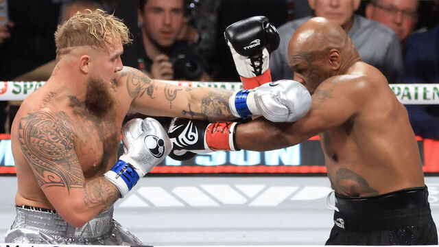 ARLINGTON, TEXAS - NOVEMBER 15: Jake Paul (L) punches Mike Tyson during their heavyweight bout at AT&T Stadium on November 15, 2024 in Arlington, Texas.