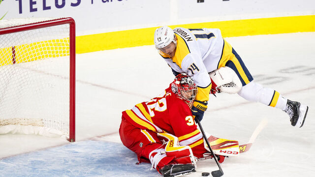 CALGARY, AB - NOVEMBER 15: Calgary Flames Goaltender Dustin Wolf (32) stops Nashville Predators center Gustav Nyquist (14) in close during the first period of an NHL game on November 15, 2024, at the Scotiabank Saddledome in Calgary, AB.