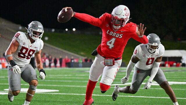 ALBUQUERQUE, NEW MEXICO - NOVEMBER 16: Quarterback Devon Dampier #4 of the New Mexico Lobos stretches out as he dives out of bounds against edge rusher Isaac Terrell #88 and linebacker Taariq (Buddah) Al-Uqdah #0 of the Washington State Cougars during the second half of a game at University Stadium on November 16, 2024 in Albuquerque, New Mexico. The Lobos defeated the Cougars 38-35.