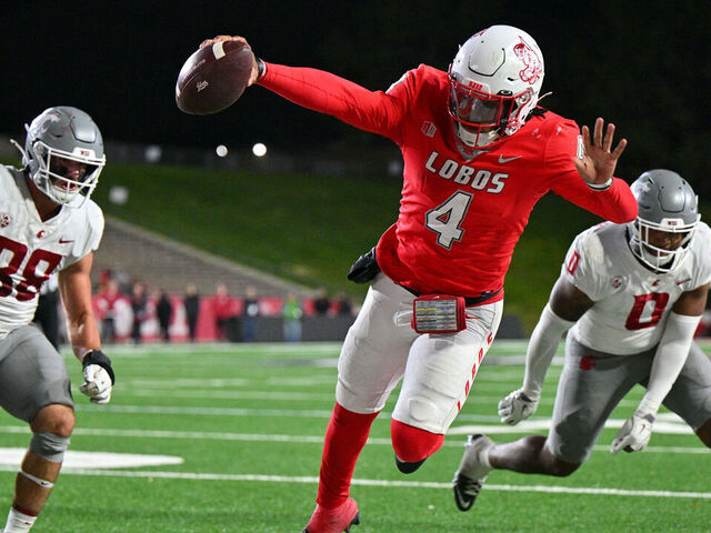 ALBUQUERQUE, NEW MEXICO - NOVEMBER 16: Quarterback Devon Dampier #4 of the New Mexico Lobos stretches out as he dives out of bounds against edge rusher Isaac Terrell #88 and linebacker Taariq (Buddah) Al-Uqdah #0 of the Washington State Cougars during the second half of a game at University Stadium on November 16, 2024 in Albuquerque, New Mexico. The Lobos defeated the Cougars 38-35.