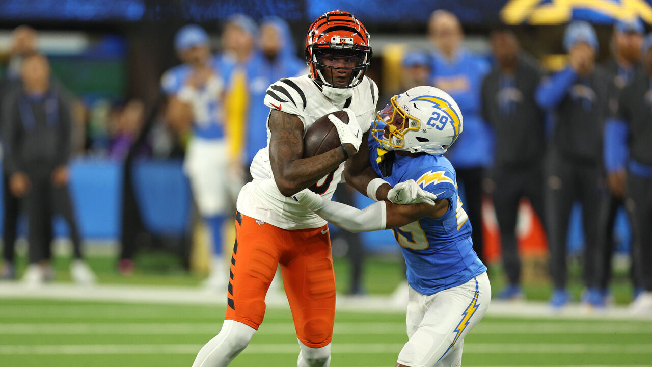 INGLEWOOD, CALIFORNIA - NOVEMBER 17: Tee Higgins #5 of the Cincinnati Bengals is hit after his reception by Tarheeb Still #29 of the Los Angeles Chargers during the first quarter at SoFi Stadium on November 17, 2024 in Inglewood, California.