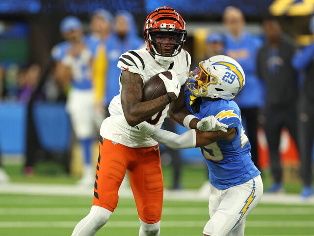 INGLEWOOD, CALIFORNIA - NOVEMBER 17: Tee Higgins #5 of the Cincinnati Bengals is hit after his reception by Tarheeb Still #29 of the Los Angeles Chargers during the first quarter at SoFi Stadium on November 17, 2024 in Inglewood, California.