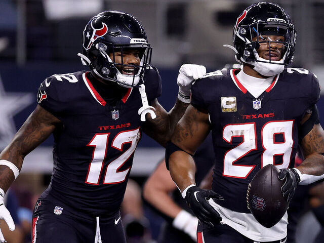 ARLINGTON, TEXAS - NOVEMBER 18: Joe Mixon #28 of the Houston Texans celebrates with Nico Collins #12 after scoring a touchdown against the Dallas Cowboys during the first quarter in the game at AT&T Stadium on November 18, 2024 in Arlington, Texas.