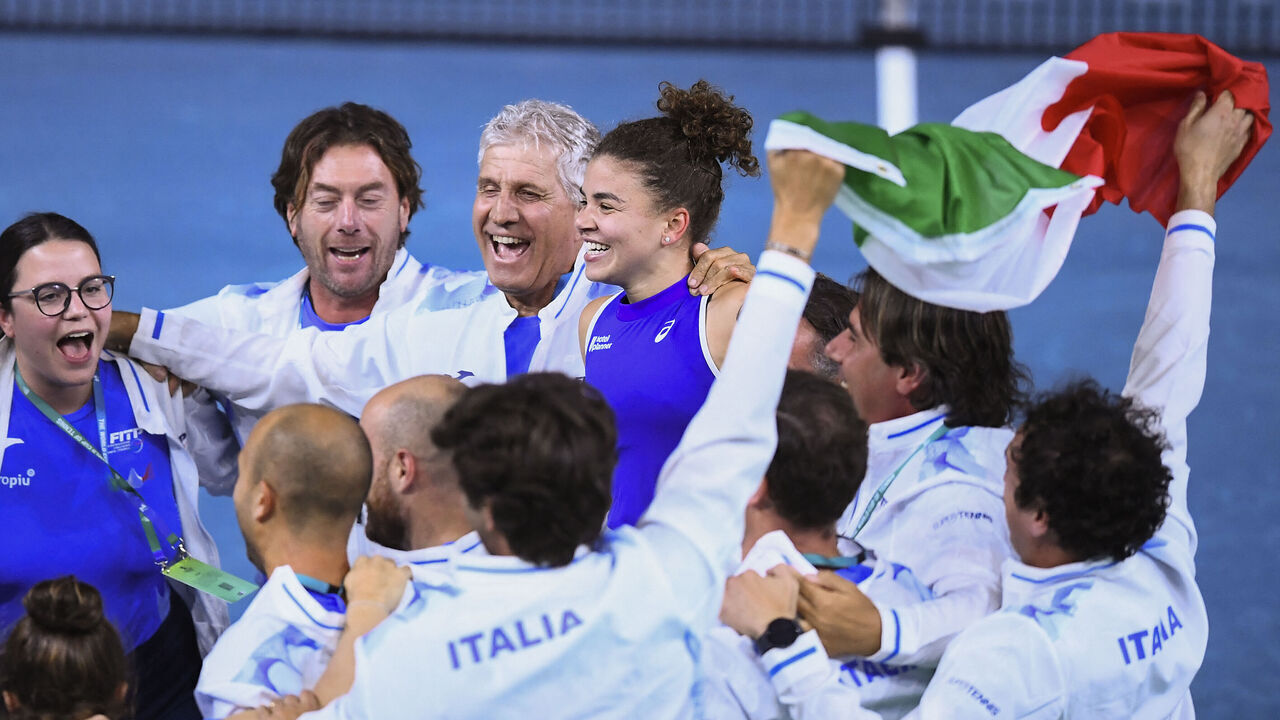 Italy's Jasmine Paolini (C top) celebrates with Team Italy teammates after defeating Slovakia's Rebecca Sramkova during their singles final tennis match between Slovakia and Italy at the Billie Jean King Cup Finals at the Palacio de Deportes Jose Maria Martin Carpena arena in Malaga, southern Spain, on November 20, 2024.