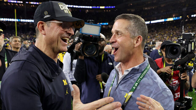HOUSTON, TEXAS - JANUARY 08: Head coach Jim Harbaugh of the Michigan Wolverines celebrates with his brother, and NFL head coach, John Harbaugh after defeating the Washington Huskies during the 2024 CFP National Championship game at NRG Stadium on January 08, 2024 in Houston, Texas. Michigan defeated Washington 34-13.
