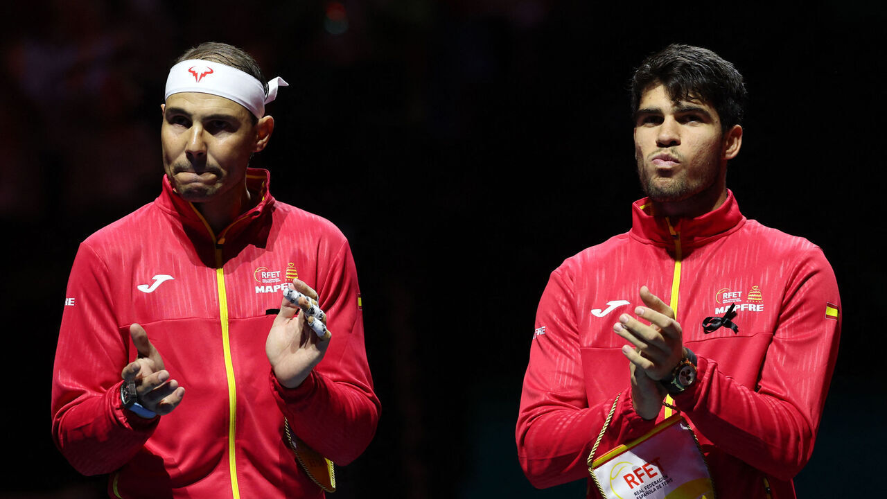 Spain's Rafael Nadal (L) applauds next to Spain's Carlos Alcaraz prior the quarter-final singles match between Netherlands and Spain during the Davis Cup Finals at the Palacio de Deportes Jose Maria Martin Carpena arena in Malaga, southern Spain, on November 19, 2024. The Davis Cup will be the final professional tournament of Nadal's glittering career of almost 23 years.