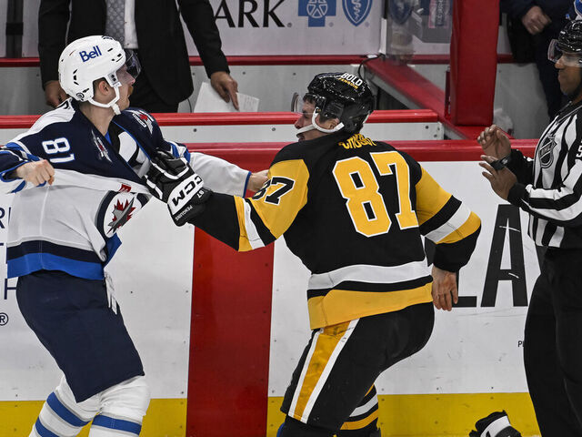 PITTSBURGH, PA - NOVEMBER 22: Winnipeg Jets left wing Kyle Connor (81) and Pittsburgh Penguins center Sidney Crosby (87) fight during the third period in the NHL game between the Pittsburgh Penguins and the Winnipeg Jets on November 22, 2024, at PPG Paints Arena in Pittsburgh, PA.