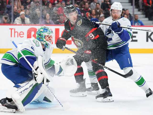 OTTAWA, CANADA - NOVEMBER 23: Josh Norris #9 of the Ottawa Senators drives to the net as Kevin Lankinen #32 and Quinn Hughes #43 of the Vancouver Canucks defend against during the first period at Canadian Tire Centre on November 23, 2024 in Ottawa, Ontario, Canada.