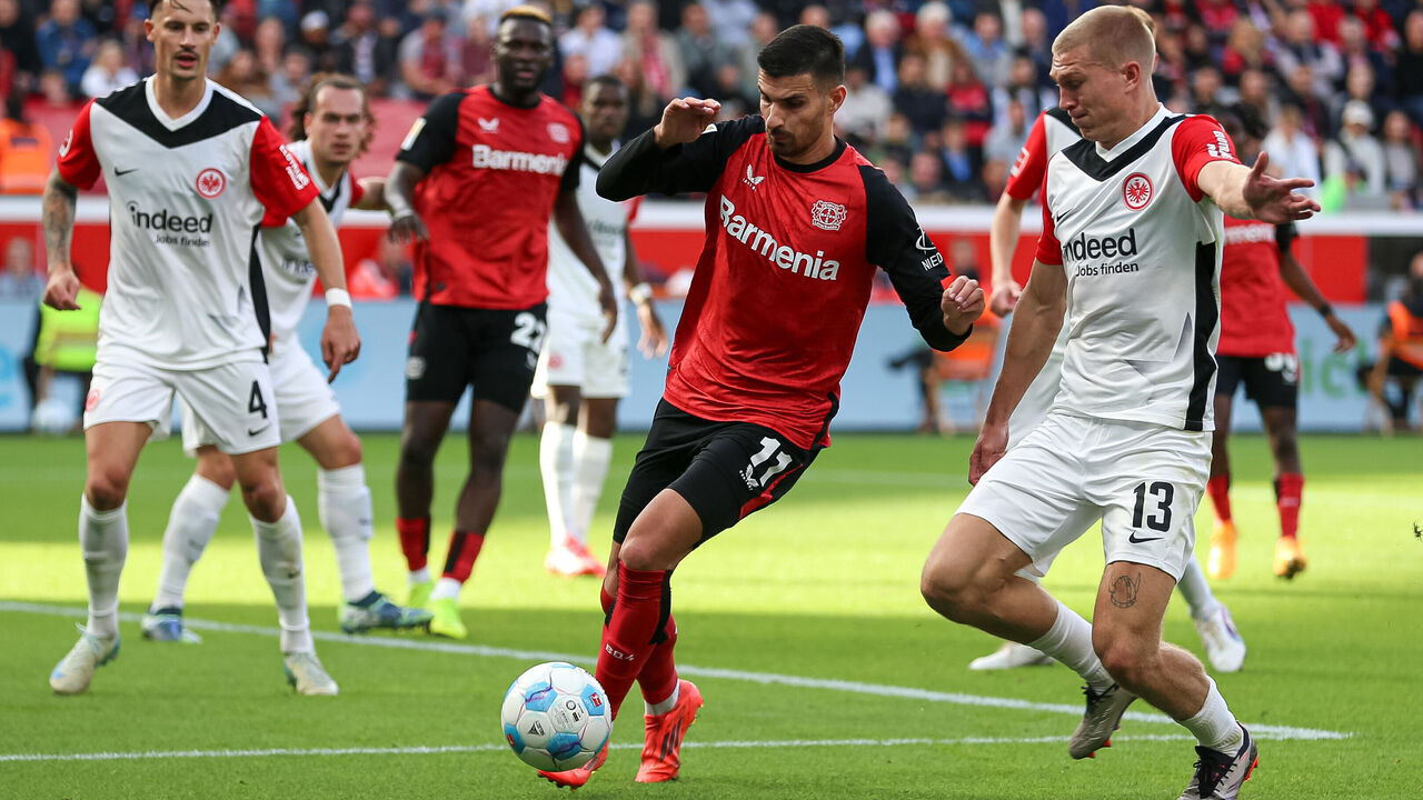 Leverkusen, Germany - October 19: Martin Terrier of Bayer 04 Leverkusen and Rasmus Kristensen of Eintracht Frankfurt battle for the ball during the Bundesliga match between Bayer 04 Leverkusen and Eintracht Frankfurt at BayArena on October 19, 2024 in Leverkusen, Germany.
