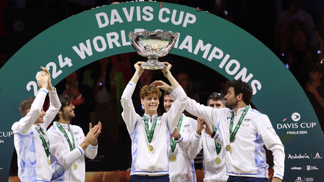 Italy's Jannik Sinner raises the trophy with teammates after winning the Davis Cup Finals at the Palacio de Deportes Jose Maria Martin Carpena arena in Malaga, southern Spain, on November 24, 2024.