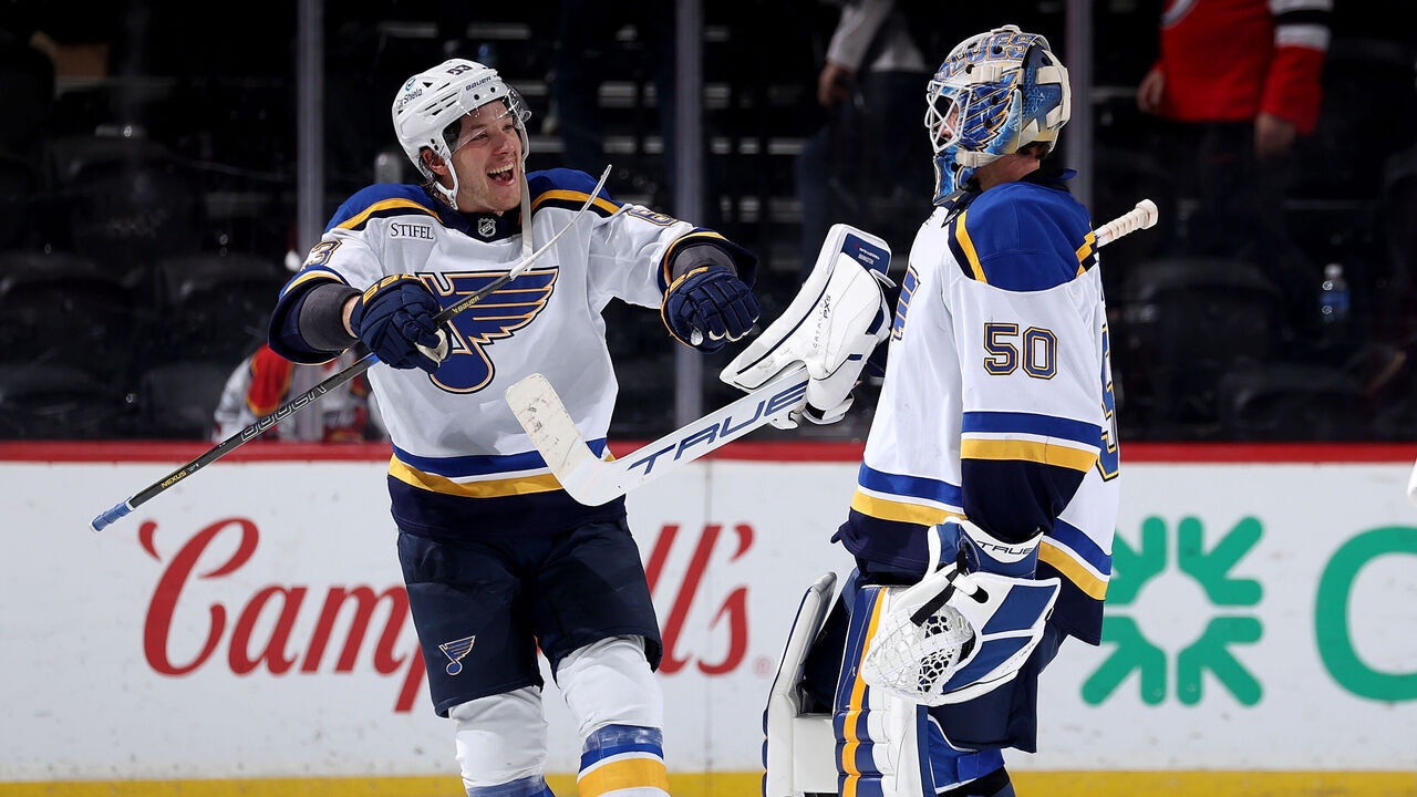 NEWARK, NEW JERSEY - NOVEMBER 27: Jake Neighbours #63 of the St. Louis Blues congratulates Jordan Binnington #50 after he recorded the shutout after the third period against the New Jersey Devils at Prudential Center on November 27, 2024 in Newark, New Jersey. The St. Louis Blues defeated the New Jersey Devils 3-0.