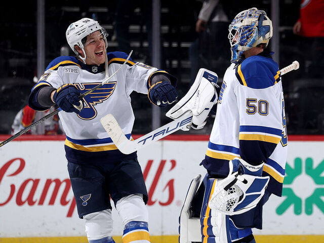 NEWARK, NEW JERSEY - NOVEMBER 27: Jake Neighbours #63 of the St. Louis Blues congratulates Jordan Binnington #50 after he recorded the shutout after the third period against the New Jersey Devils at Prudential Center on November 27, 2024 in Newark, New Jersey. The St. Louis Blues defeated the New Jersey Devils 3-0.