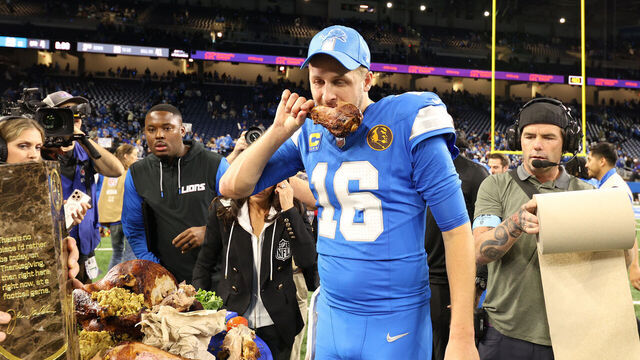 DETROIT, MICHIGAN - NOVEMBER 28: Quarterback Jared Goff #16 of the Detroit Lions eats turkey during a CBS interview after beating the Chicago Bears 23-20 at Ford Field on November 28, 2024 in Detroit, Michigan.
