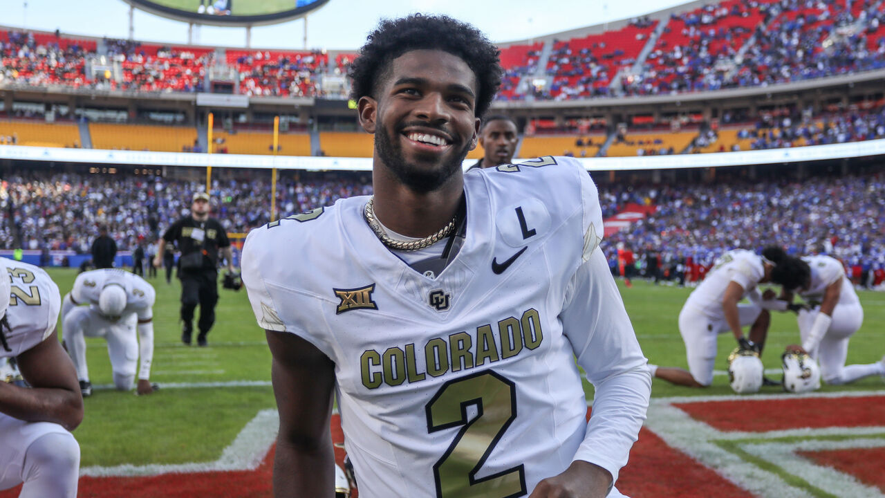 KANSAS CITY, MO - NOVEMBER 23: Colorado Buffaloes quarterback Shedeur Sanders (2) kneels and smiles before a Big 12 game between the Colorado Buffaloes and Kansas Jayhawks on November 23, 2024 at GEHA Field at Arrowhead Stadium in Kansas City, MO.
