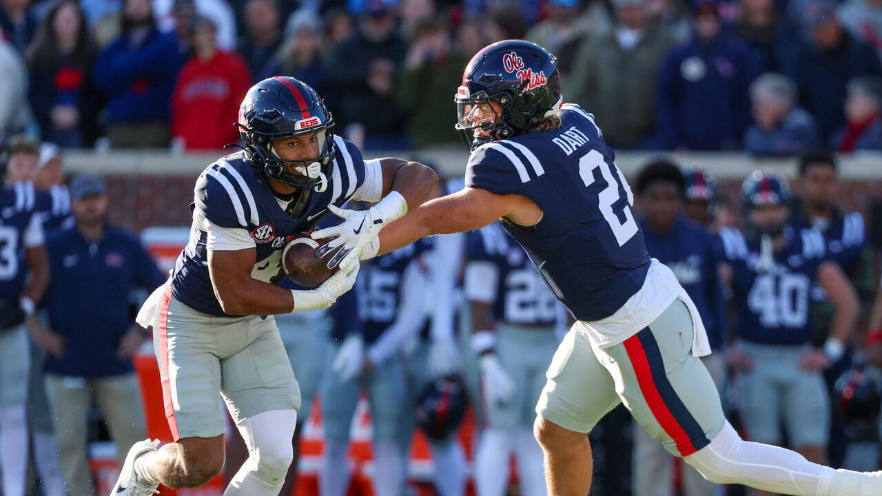 OXFORD, MISSISSIPPI - NOVEMBER 29: Jaxson Dart #2 of the Mississippi Rebels hands the ball to Micah Davis #4 during the first half against the Mississippi State Bulldogs at Vaught-Hemingway Stadium on November 29, 2024 in Oxford, Mississippi.