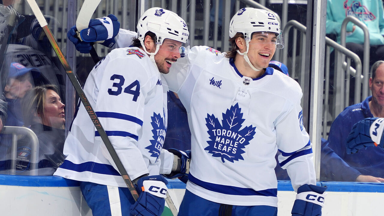ELMONT, NEW YORK - JANUARY 11: Auston Matthews #34 of the Toronto Maple Leafs is congratulated by Matthew Knies #23 after scoring a goal against the New York Islanders during the second period at UBS Arena on January 11, 2024 in Elmont, New York.