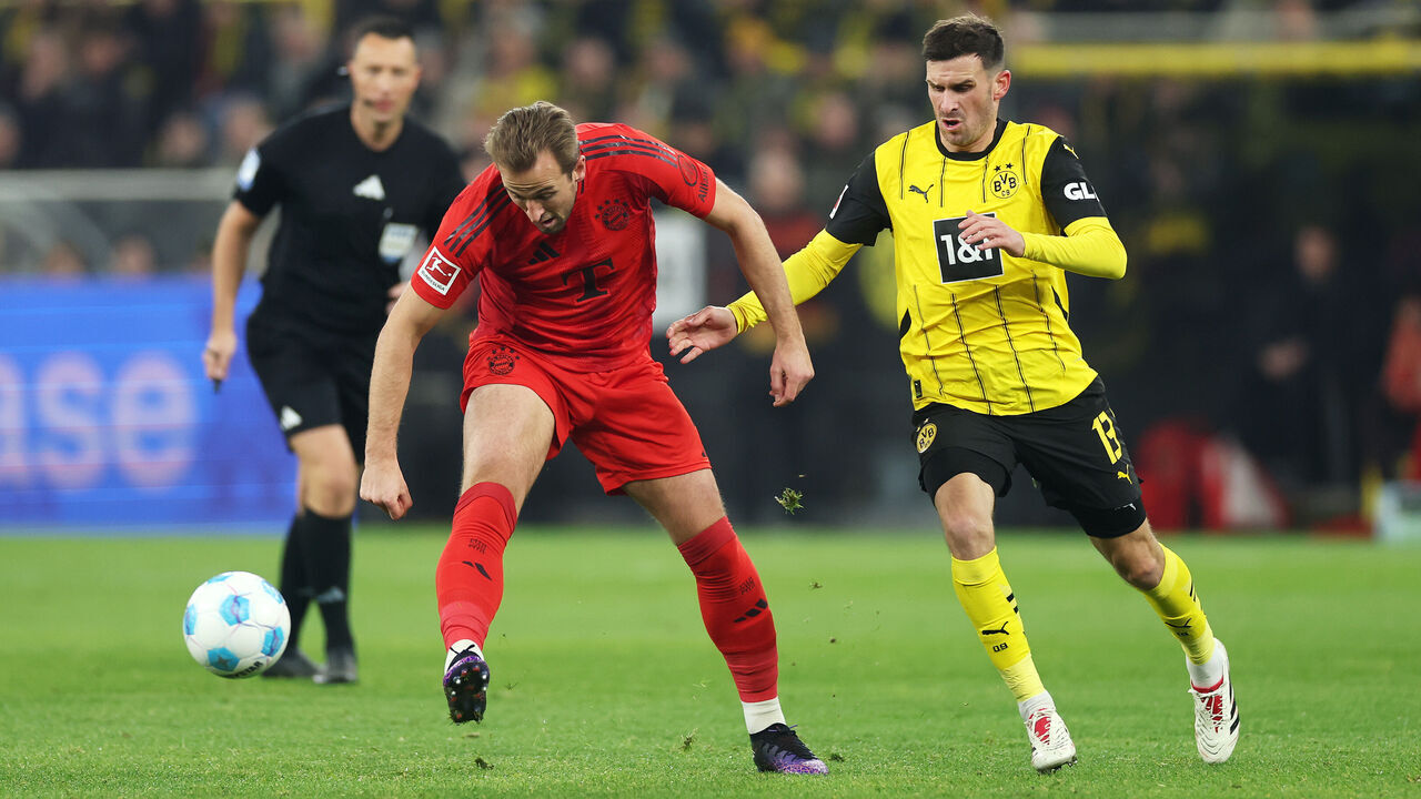 DORTMUND, GERMANY - NOVEMBER 30: Harry Kane of Bayern Munich passes the ball whilst under pressure from Pascal Gross of Borussia Dortmund during the Bundesliga match between Borussia Dortmund and FC Bayern München at Signal Iduna Park on November 30, 2024 in Dortmund, Germany.