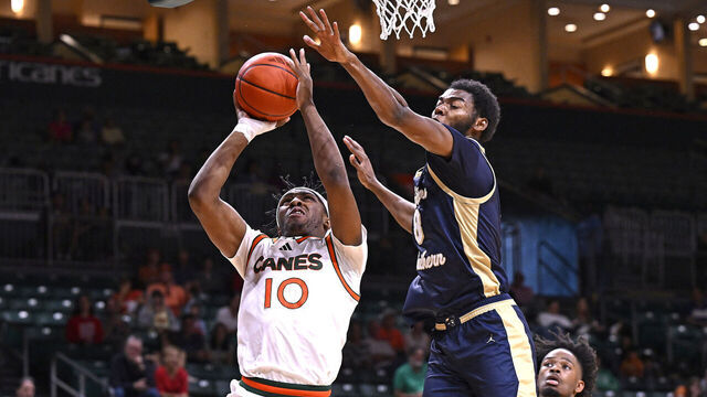 CORAL GABLES, FL - NOVEMBER 30: Miami guard Paul Djobet (10) puts up a basket while defended by Charleston Southern forward Jaylon Gibson (8) in the second half as the Miami Hurricanes faced the Charleston Southern Buccaneers on November 30, 2024, at the Watsco Center in Coral Gables, Florida.
