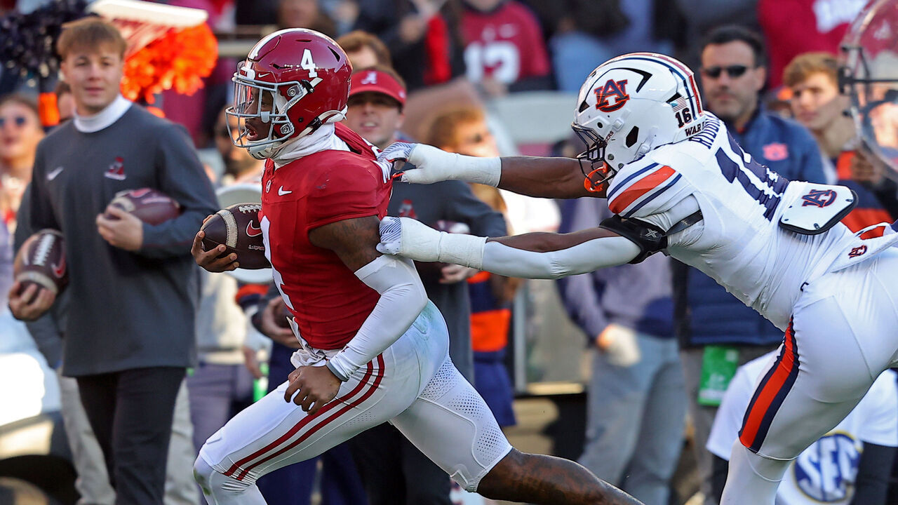 TUSCALOOSA, ALABAMA - NOVEMBER 30: Jalen Milroe #4 of the Alabama Crimson Tide breaks a tackle by Demarcus Riddick #16 of the Auburn Tigers as Milroe rushes for a touchdown during the first half at Bryant-Denny Stadium on November 30, 2024 in Tuscaloosa, Alabama.
