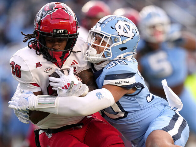 CHAPEL HILL, NORTH CAROLINA - NOVEMBER 30: Michael Short #30 of the North Carolina Tar Heels tackles Hollywood Smothers #20 of the North Carolina State Wolfpack during the first half of the game at Kenan Memorial Stadium on November 30, 2024 in Chapel Hill, North Carolina.