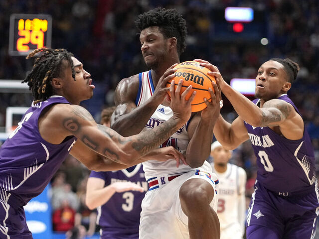 LAWRENCE, KANSAS - NOVEMBER 30: KJ Adams Jr. #24 of the Kansas Jayhawks battle for the ball against Tyrese Hughey #6 and PJay Smith Jr. #0 of the Furman Paladins in the first half at Allen Fieldhouse on November 30, 2024 in Lawrence, Kansas.