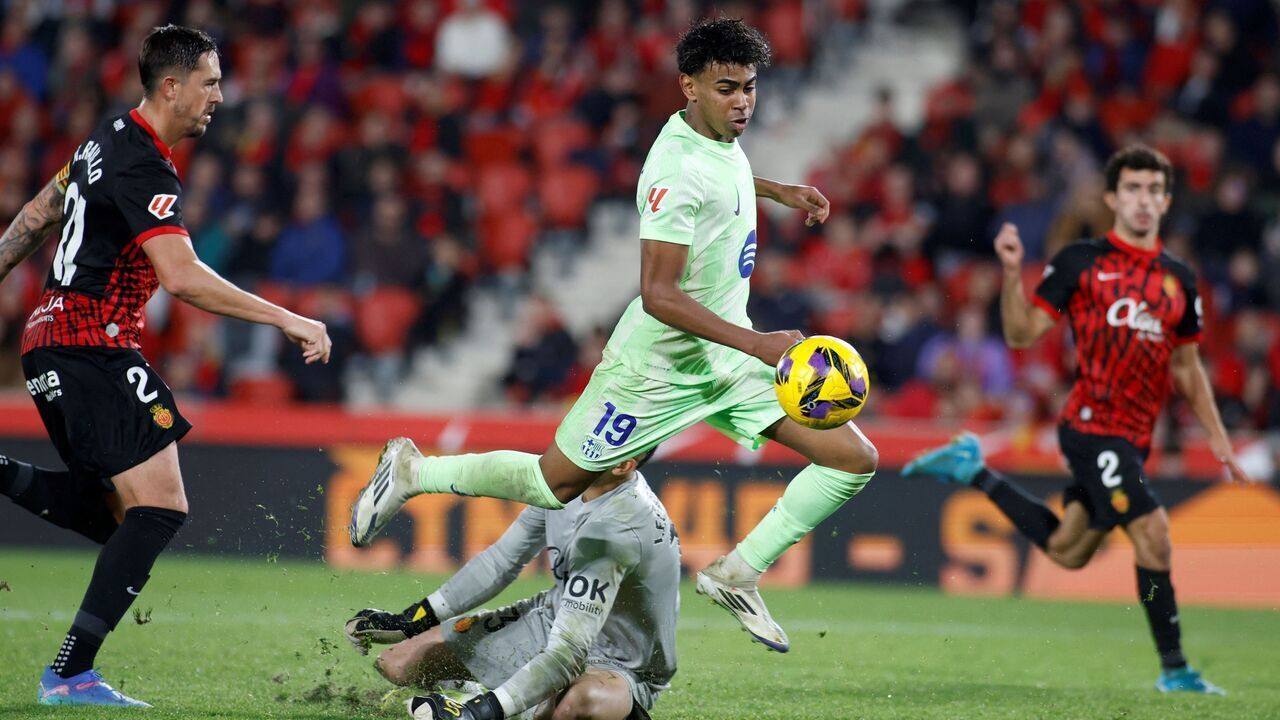 Barcelona's Spanish forward #19 Lamine Yamal challenges Real Mallorca's Spanish goalkeeper #13 Leo Roman during the Spanish league football match between RCD Mallorca and FC Barcelona at the Mallorca Son Moix stadium in Palma de Mallorca on December 3, 2024.