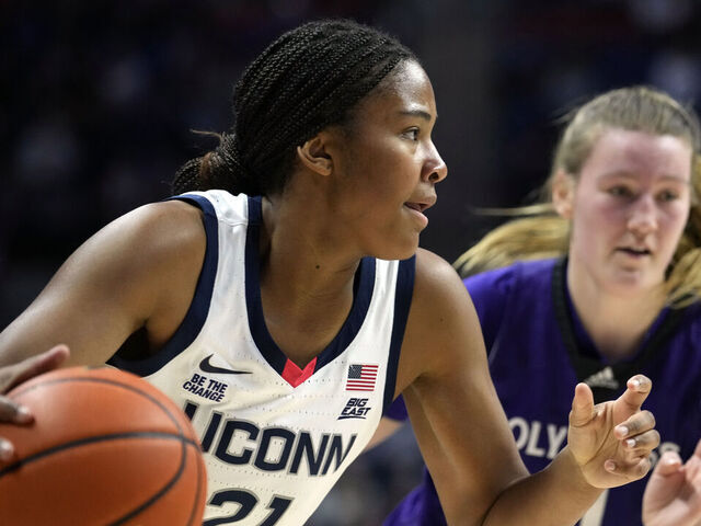 STORRS, CONNECTICUT - DECEMBER 3: Sarah Strong #21 of the Connecticut Huskies is defended by Meg Cahalan #4of the Holy Cross Crusaders during the first half of an NCAA women's basketball game at the Harry A. Gampel Pavilion on December 3, 2024 in Storrs, Connecticut.