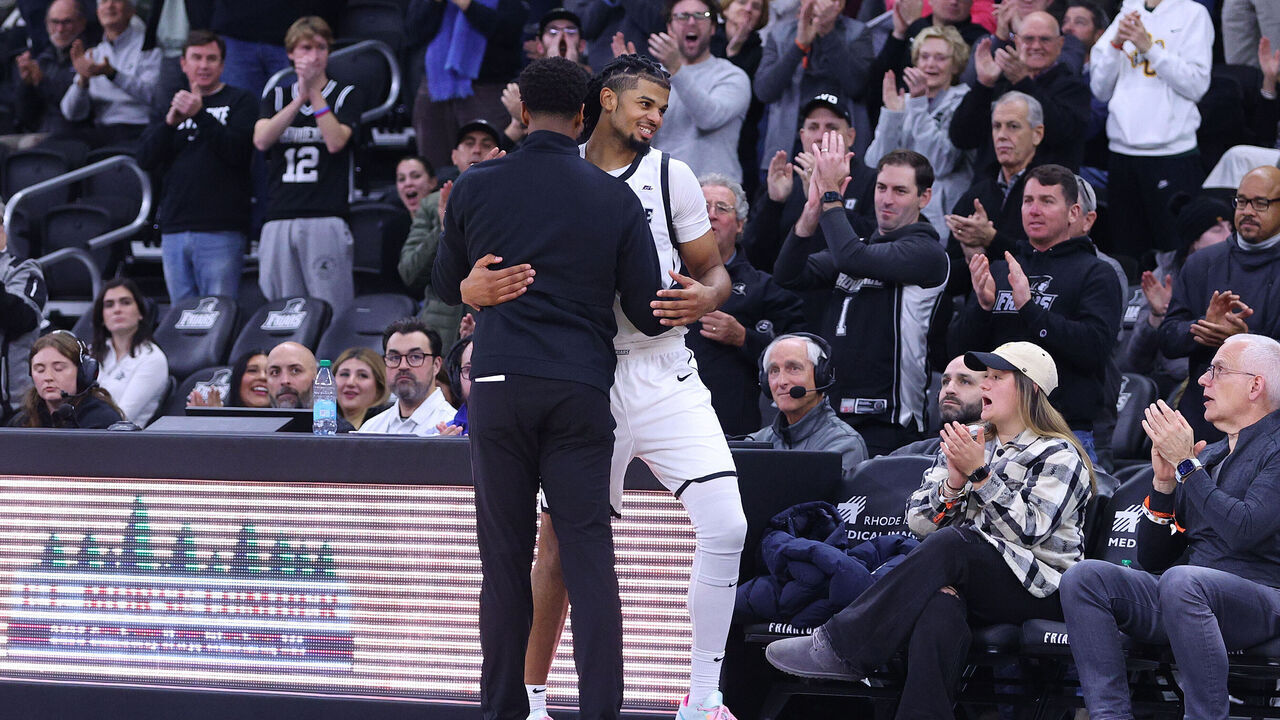 PROVIDENCE, RI - DECEMBER 03: Providence Friars head coach Kim English and Providence Friars forward Bryce Hopkins (23) embrace as he heads to the bench during the closing minutes of the college Basketball game between BYU Cougars and Providence Friars on December 3, 2024, at Amica Mutual Pavilion in Providence, RI.