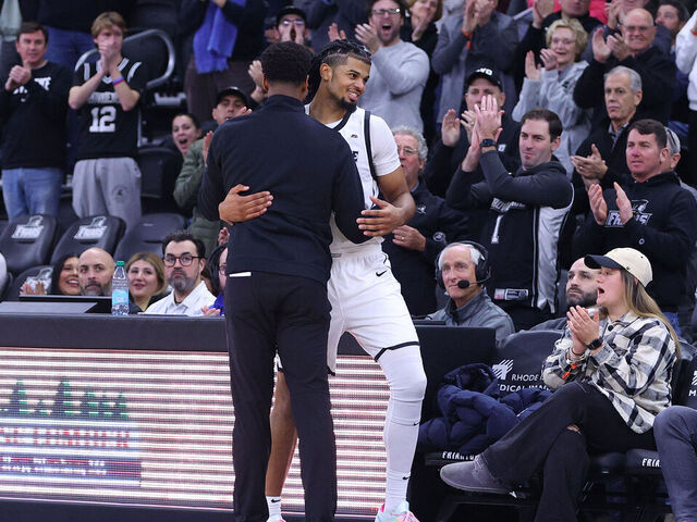 PROVIDENCE, RI - DECEMBER 03: Providence Friars head coach Kim English and Providence Friars forward Bryce Hopkins (23) embrace as he heads to the bench during the closing minutes of the college Basketball game between BYU Cougars and Providence Friars on December 3, 2024, at Amica Mutual Pavilion in Providence, RI.