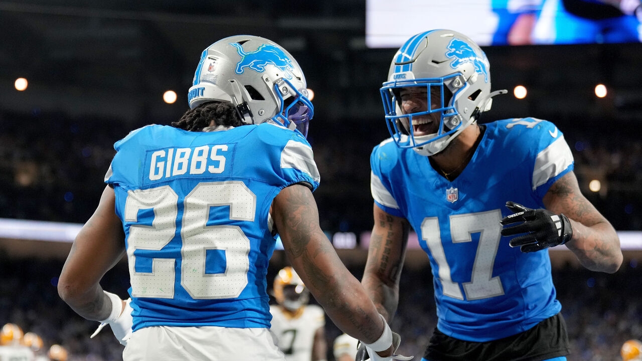 DETROIT, MICHIGAN - DECEMBER 05: Jahmyr Gibbs #26 of the Detroit Lions celebrates with Tim Patrick #17 after scoring a touchdown against the Green Bay Packers during the second quarter in the game at Ford Field on December 05, 2024 in Detroit, Michigan.
