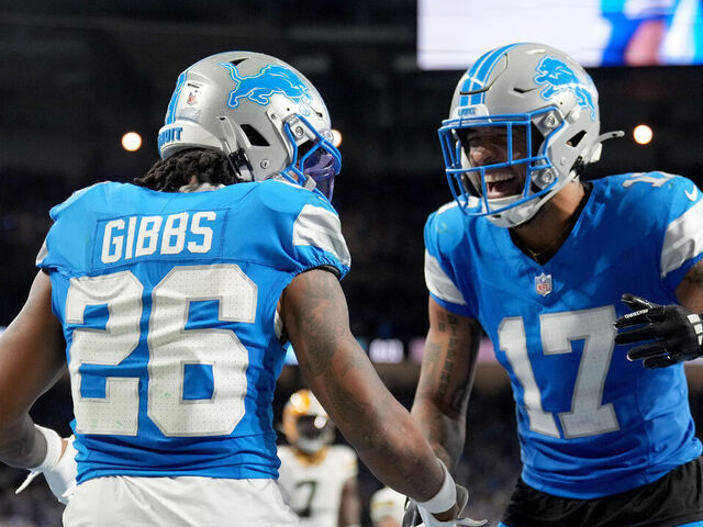 DETROIT, MICHIGAN - DECEMBER 05: Jahmyr Gibbs #26 of the Detroit Lions celebrates with Tim Patrick #17 after scoring a touchdown against the Green Bay Packers during the second quarter in the game at Ford Field on December 05, 2024 in Detroit, Michigan.